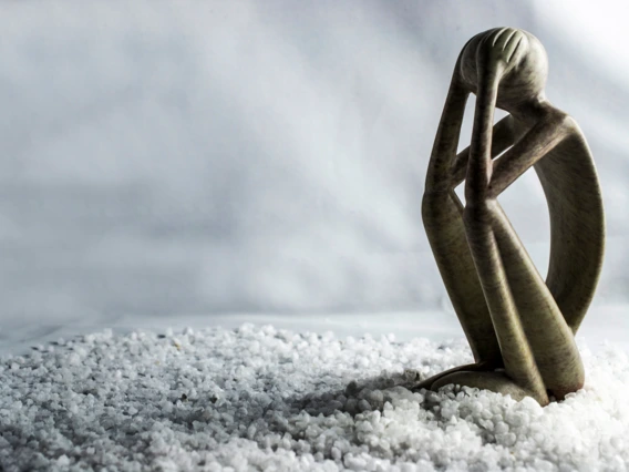Stylized image of a human figure sitting in an attitude that communicates stress, anxiety, or sadness