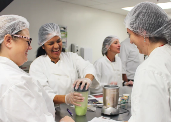 Participants in the Sports Nutrition Conference make smoothies in the food lab.