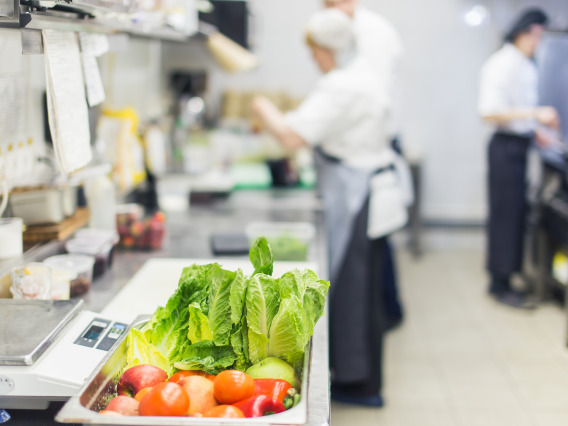 A bucket of vegetables in a food prep kitchen.