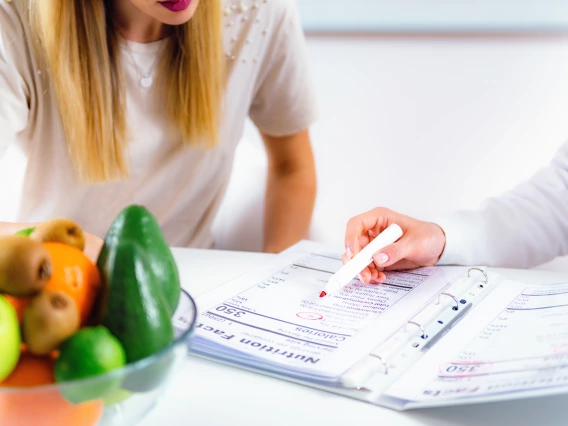 Two people looking at a binder of nutritional facts.