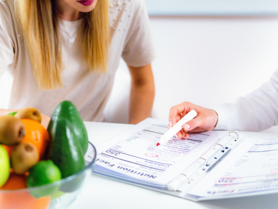 Two people looking at a binder of nutritional facts.