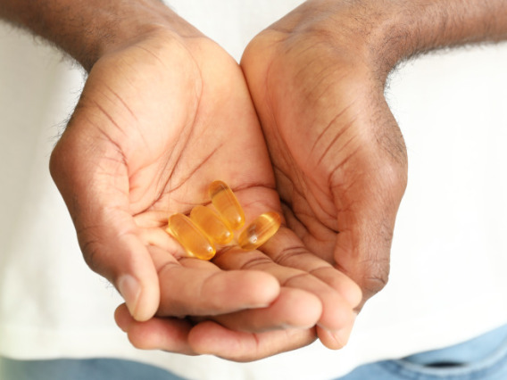 a person holds fish oil supplements in their hands